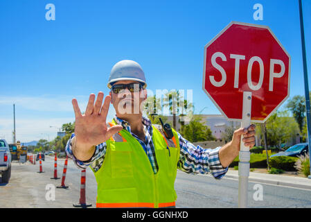 Kaukasische Flagger gestikulieren Stop mit Stop-Schild Stockfoto