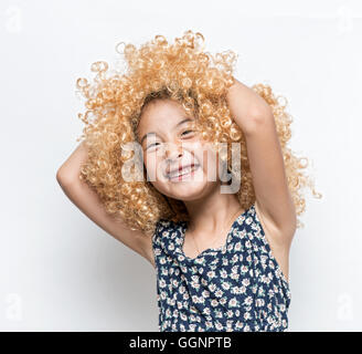 Trägt eine blonde Perücke und lustige Mimik Asiatin Stockfoto