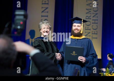 Graduierung Kandidat in Mütze und Mantel erhält Diplom an Western Governors University Abschlussfeier in Orlando, FL Stockfoto