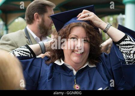 Western Governors University Abschluss Kandidat passt Doktorhut vor Beginn der Abschlussfeier in Orlando, Florida. Stockfoto