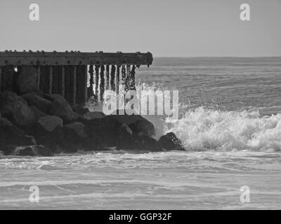 Schwarz / weiß Bild der Welle stürzt auf Ozean pier Stockfoto