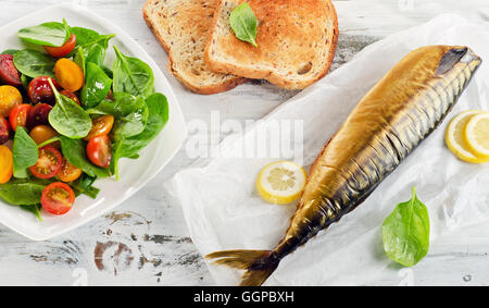 Geräucherte Makrele mit Zitrone, Toast und gesunden Salat. Ansicht von oben Stockfoto