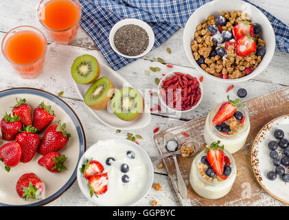 Gesundes Frühstück mit Müsli, Joghurt, Saft, Obst und Superfoods. Ansicht von oben Stockfoto