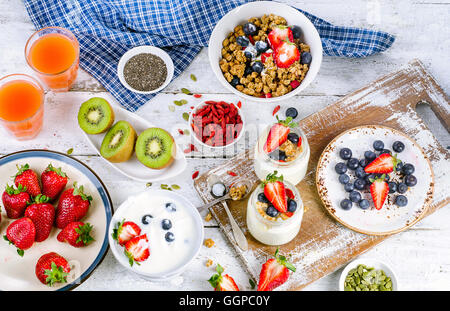 Gesundes Frühstück mit Müsli, Joghurt, Saft, Obst und Beeren. Ansicht von oben Stockfoto