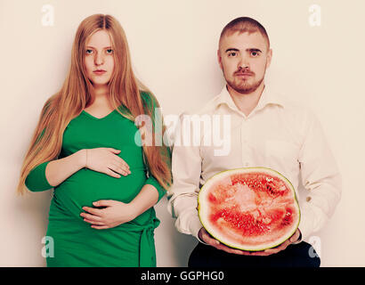 Mann hält Wassermelone mit schwangere Freundin Stockfoto