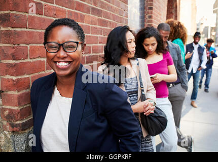 Menschen in der Schlange warten auf Bürgersteig Stockfoto