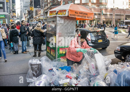 alte Dame in Korallen Parka ordentlich gekleidet & ziemlich Schal Sonden recycling-Taschen mit Gummihandschuhen, Ergebnis von einem anstrengenden Tag zu sammeln Stockfoto