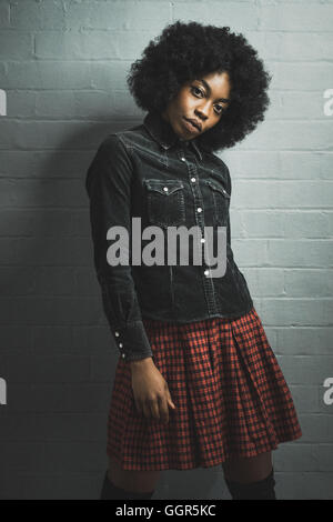 Die junge Afro Caribbean-Frau in schwarzem Denim-Hemd posiert für ein Fashion-Shooting Stockfoto