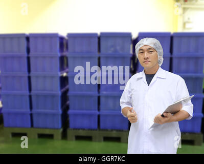 Ein Mann im weißen großen Mantel uniform und Kunststoff Container-Box des Hintergrunds für Concept Design Quality Inspection Business. Stockfoto