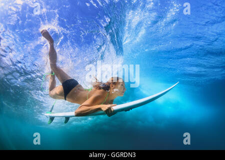 Aktive Mädchen im Bikini in Aktion - Surfer mit Surf Board Tauchgang unter Wasser unter großen Ozeanwelle. Schule