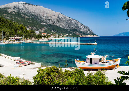 Blick auf Poros Hafen Blick Norden mit Fischerboot auf dem Steg und fernen Ithaka; Kefalonia, Griechenland. Stockfoto