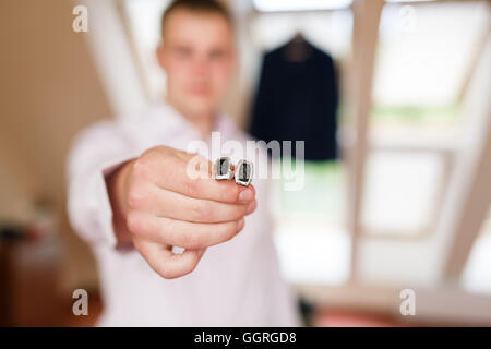 Man legt die Manschettenknöpfe in einem Raum Stockfoto