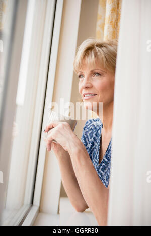 Ältere Frau kaukasischen Kaffeetrinken am Fenster Stockfoto