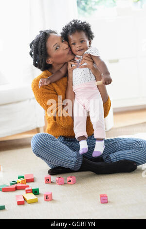 Lächelnde schwarze Mutter Tochter küssen Stockfoto