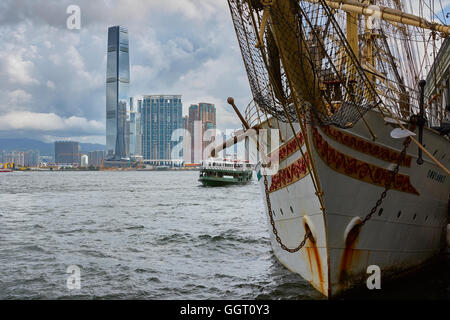 Die norwegische Tall Ship, Sørlandet, an der Zentralen Anlegestelle der Fähre, die im Hintergrund die Skyline von Kowloon, Hong Kong vor Anker. Stockfoto