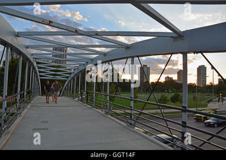 Zwei junge Männer Fuß über die Fußgängerbrücke über Lake Shore Drive von Lincoln Park zu der North Avenue Beach führt. Stockfoto