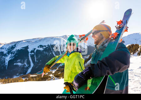 Paar Ski auf verschneiten Berg tragen Stockfoto