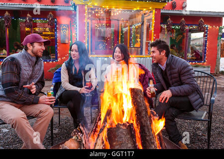 Paare, trinken Cocktails und Bier im Freien am Schaufenster Lagerfeuer Stockfoto