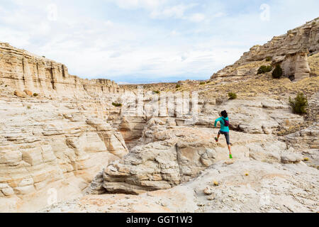 Frauen springen in Canyon Rucksack tragen Rock Stockfoto