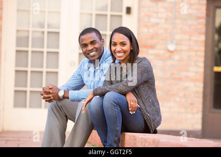 Lächelnde paar sitzen auf Stufen Stockfoto
