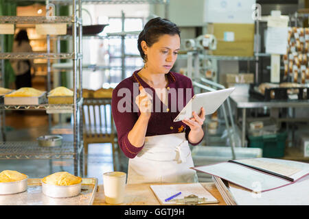 Kaukasische Frau mit digital-Tablette in Bäckerei Stockfoto