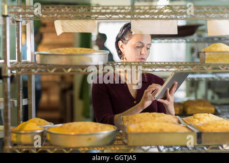 Kaukasische Frau mit digital-Tablette in Bäckerei Stockfoto