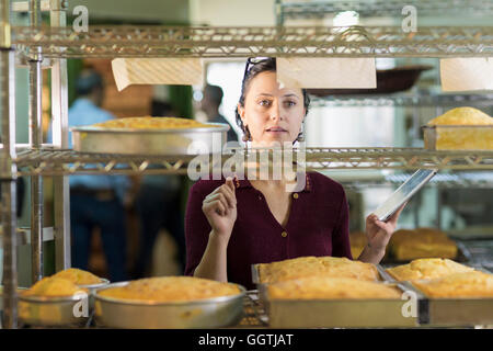 Kaukasische Frau mit digital-Tablette in Bäckerei Stockfoto