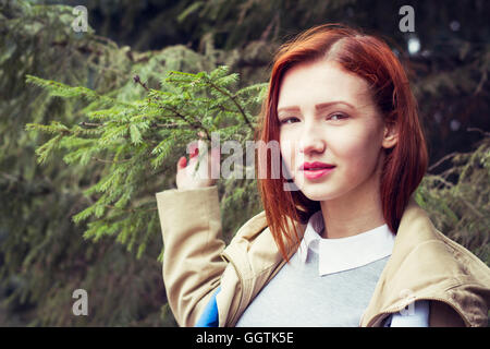 Frau mit roten Haaren halten Ast Stockfoto