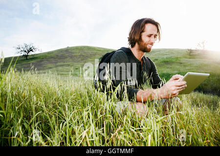 Kaukasische Wanderer hocken in Rasen am Berg mit digital-Tablette Stockfoto