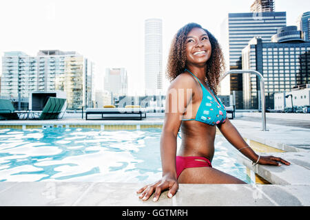 Lächelnde schwarze Frau im städtischen Schwimmbad Stockfoto