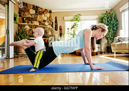 Mutter, arbeiten auf Gymnastikmatte mit Baby auf Beinen Stockfoto