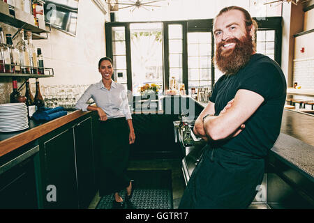 Lächelnd Barkeeper hinter bar entspannende Stockfoto