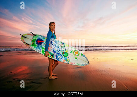 Kaukasische Frau mit Surfbrett am Strand Stockfoto