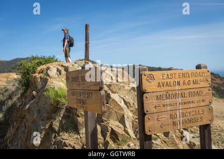 Kaukasische Wanderer stehen auf Felsen hinter Zeichen Stockfoto