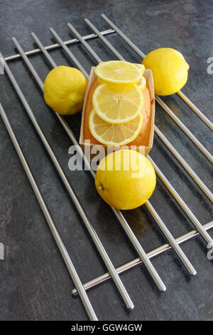Zitronenkuchen Laib auf braunem Papier dekoriert mit Zitronenscheiben Stockfoto