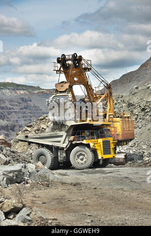 Iron Ore Mining - Bagger lädt der Muldenkipper auf den Tagebau Stockfoto