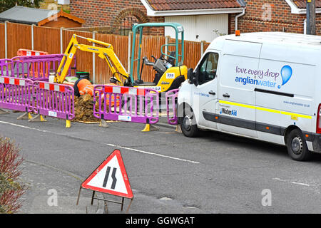 Anglian Wasser Crew und van Teilnahme an Straße Kanalanschluss von Wohneigentum Straße & Pflaster mit Minibagger Graben Maschine England UK Stockfoto