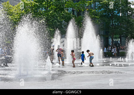 Kinder spielen in variabler Höhe Springbrunnen Jets nach dem Zufallsprinzip Timings im heißen Sommer Wetter ideal für Kinder im Freien London England Großbritannien Stockfoto