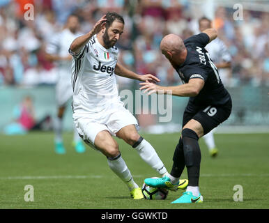 Juventus Turin Gonzalo Higuain (links) und West Ham United James Collins Kampf um den Ball während des Betway Cup match bei London Stadium. Stockfoto