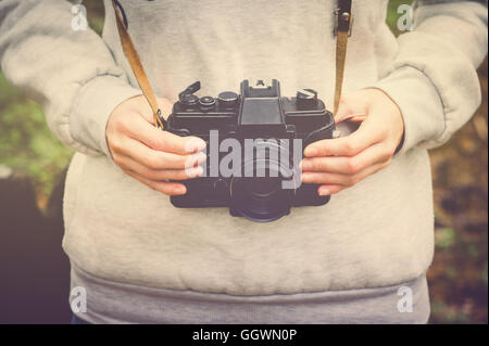 Frau Händen mit Retro-Fotokamera Wandern outdoor Lifestyle Hipster Travel Konzept Retro-Farben Stockfoto