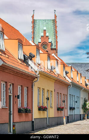 Eine Reihe von Pastelltönen gestrichenen Häuser in Trelleborg, Schweden. Die Kirche im Hintergrund. Stockfoto