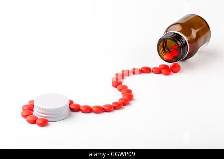 Von einem Glas Apotheker Flasche roten Pillen auf weißem Hintergrund verschüttet Stockfoto