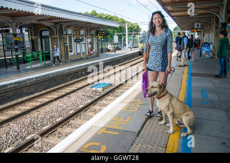 Frau mit Hund warten in Berkhamsted Bahnhof Zug nach London Stockfoto