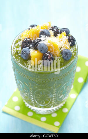 Frühstück grüner Smoothie Schüssel garniert mit Mango, Bluebery und blackberry Stockfoto