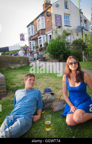 Ein paar genießt Bier auf Rasen von Rising Sun Pub am Rande des Grand Union Canal - Berkhamsted, UK Stockfoto