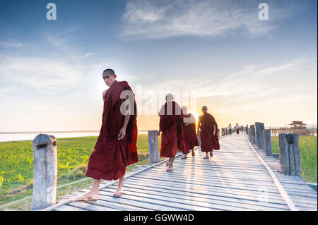 Buddhistische Mönche Sonnenuntergang laufen auf U Bein Brücke Stockfoto
