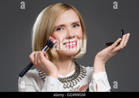 Schöne mittlere gealterte Frau Anwendung erröten Stockfoto
