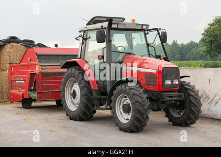 Roter Traktor mit Rotvieh feed Diffusor auf einem Milchviehbetrieb Stockfoto