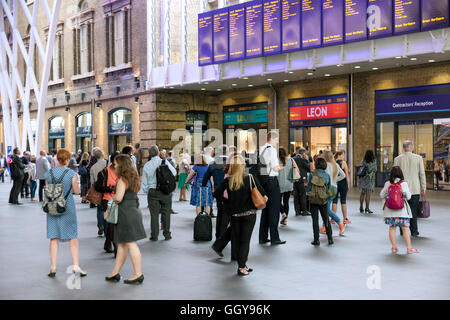 Menge von Pendlern, die Überprüfung der Abfahrtstafeln an der Kings Cross Bahnhof in London Stockfoto