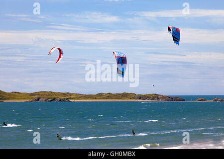 Kitesurfer genießen Wind und Wetter am Strand Newborough, Anglesey, Wales, UK Stockfoto